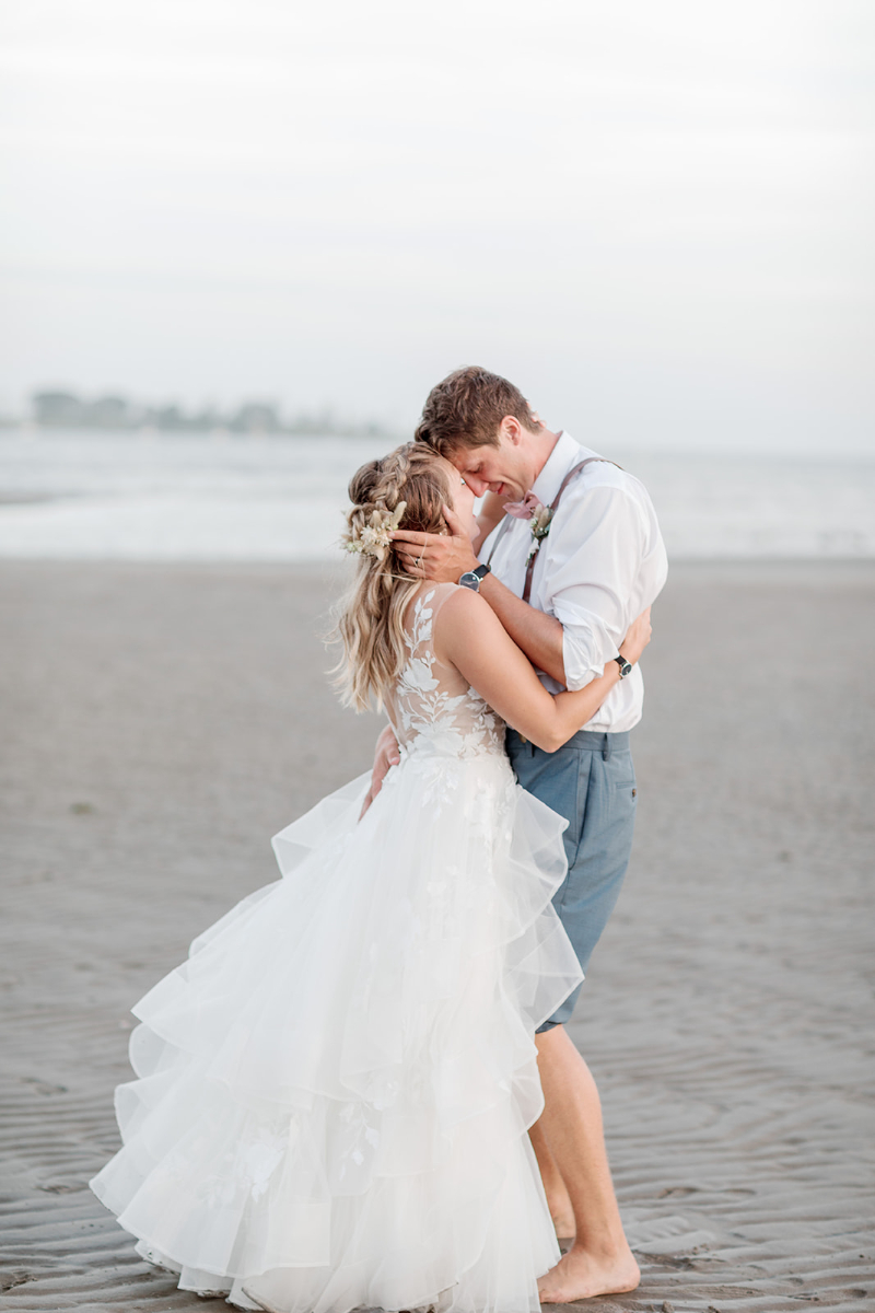 Bride and groom kissing on beach