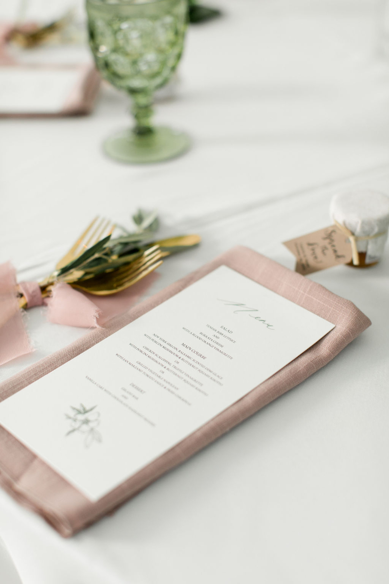 closeup of menu cards and blush napkins